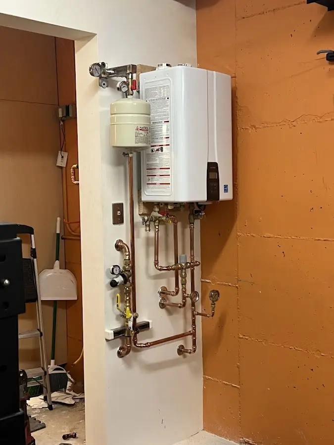 Plumbing technician inspecting water heater connections in Fleming Island